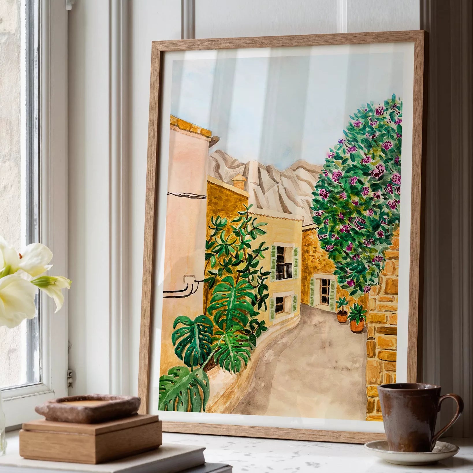 Ilustración en acuarela de un pueblo mediterráneo, una calle con luz cálida y colores vibrantes, obra de Karen Menzenbach