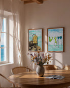 Composición de pared con varias láminas de temática marina y mediterránea en un salón de estilo contemporáneo.