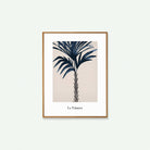 Una palmera con las hojas azules y el fondo beige