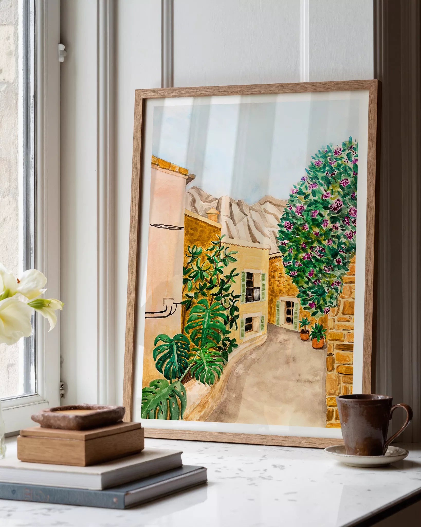 Ilustración en acuarela de un pueblo mediterráneo, una calle con luz cálida y colores vibrantes, obra de Karen Menzenbach